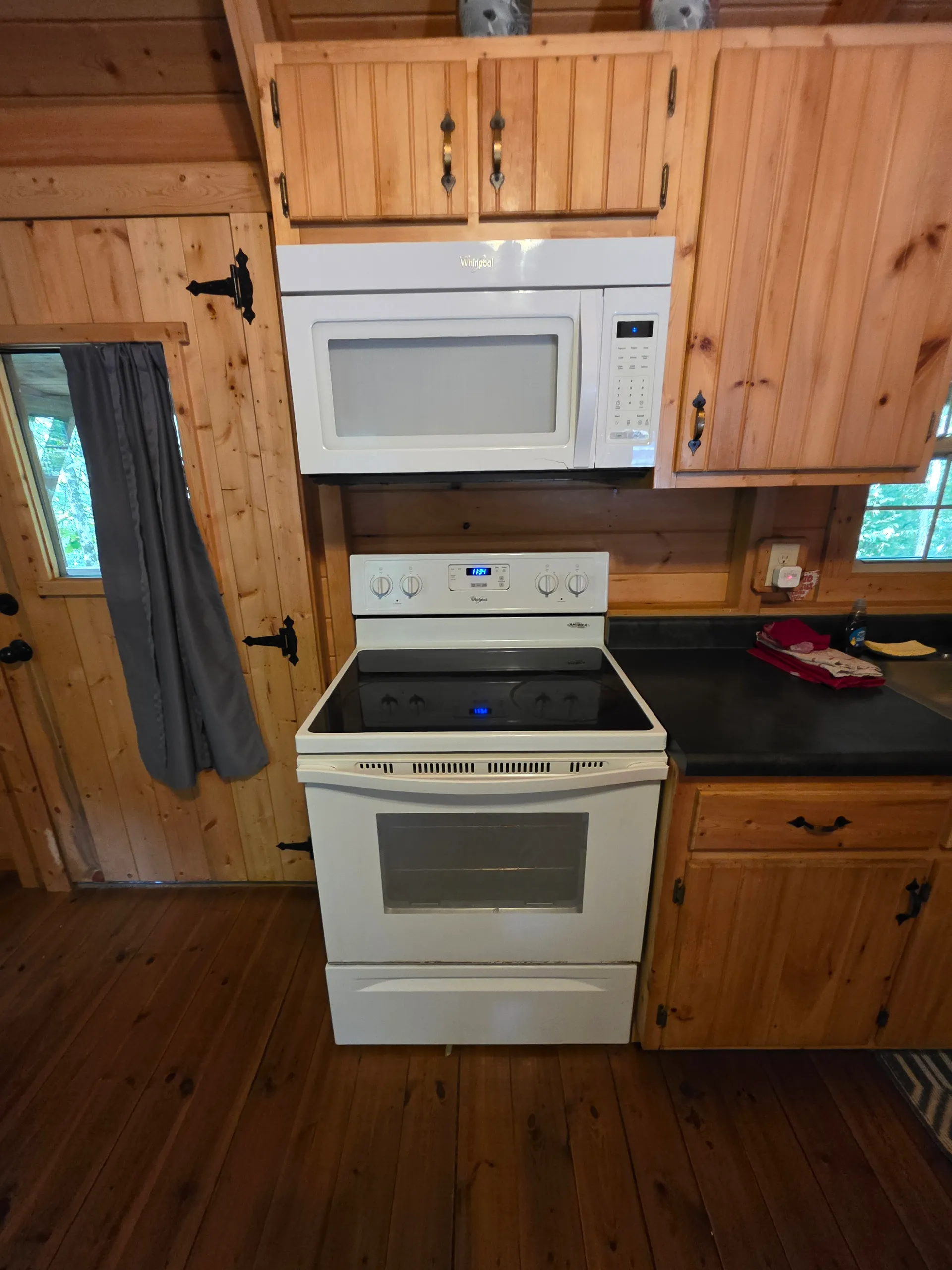 Kitchen appliances with stove, microwave, and pine cabinetry at Buckeye Hut cabin