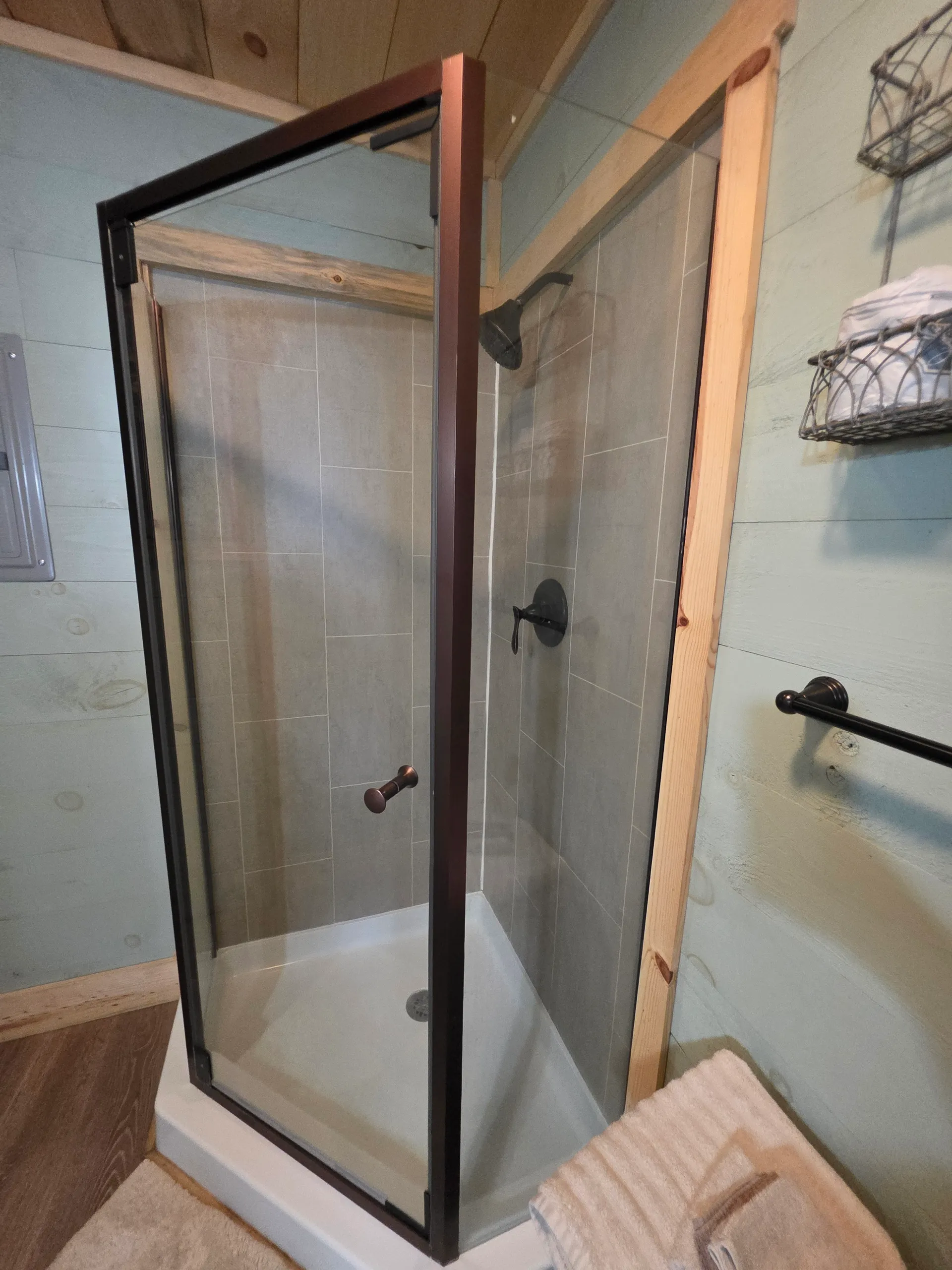 Glass-enclosed walk-in shower with gray tile and rainfall showerhead at Butterfly Ridge cabin