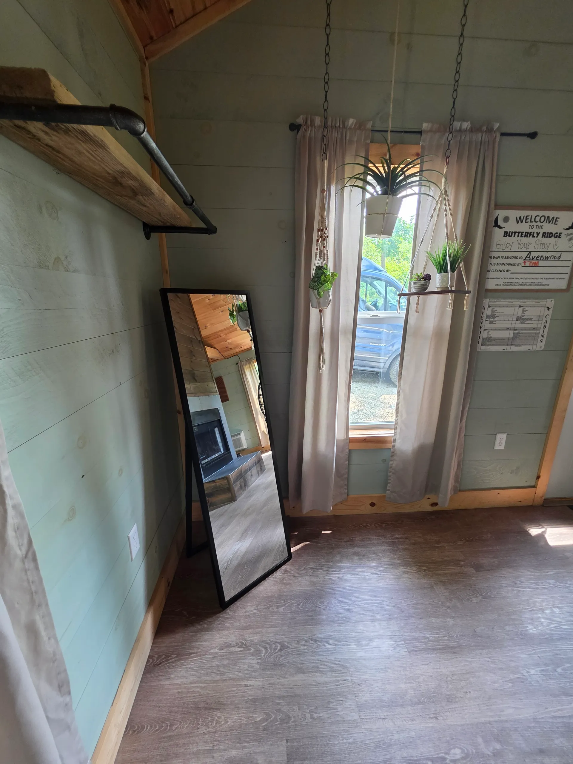 Queen bed with white linens, tufted headboard, and framed nature prints at Butterfly Ridge cabin