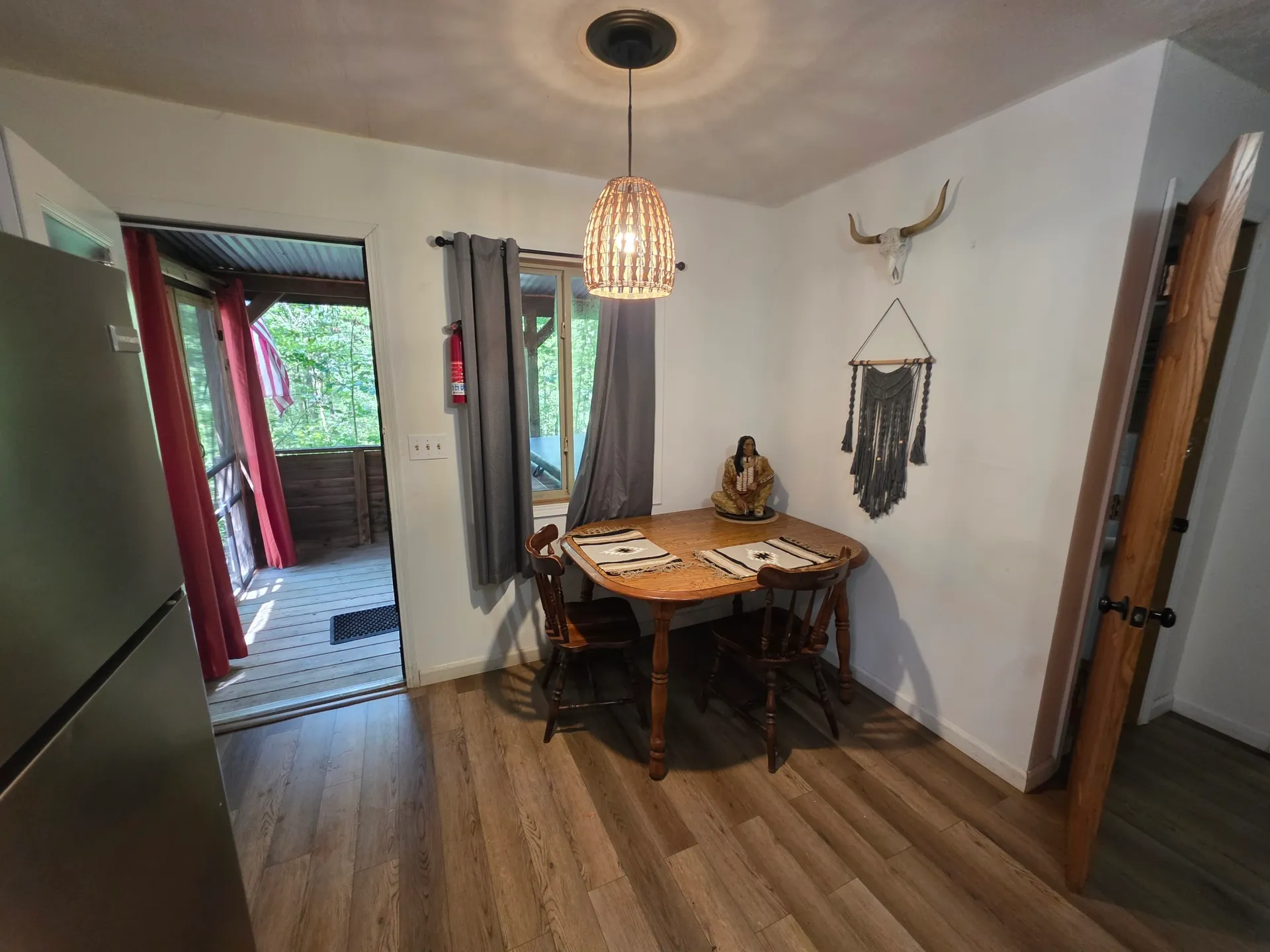 Dining nook with rustic table, woven pendant light, and Native American inspired decor at Cherokee Way cabin