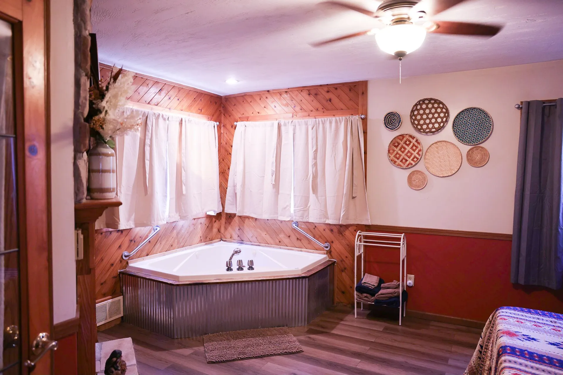 Spacious jacuzzi room with corner tub, woven basket wall art, and warm pine paneling at Cherokee Way cabin