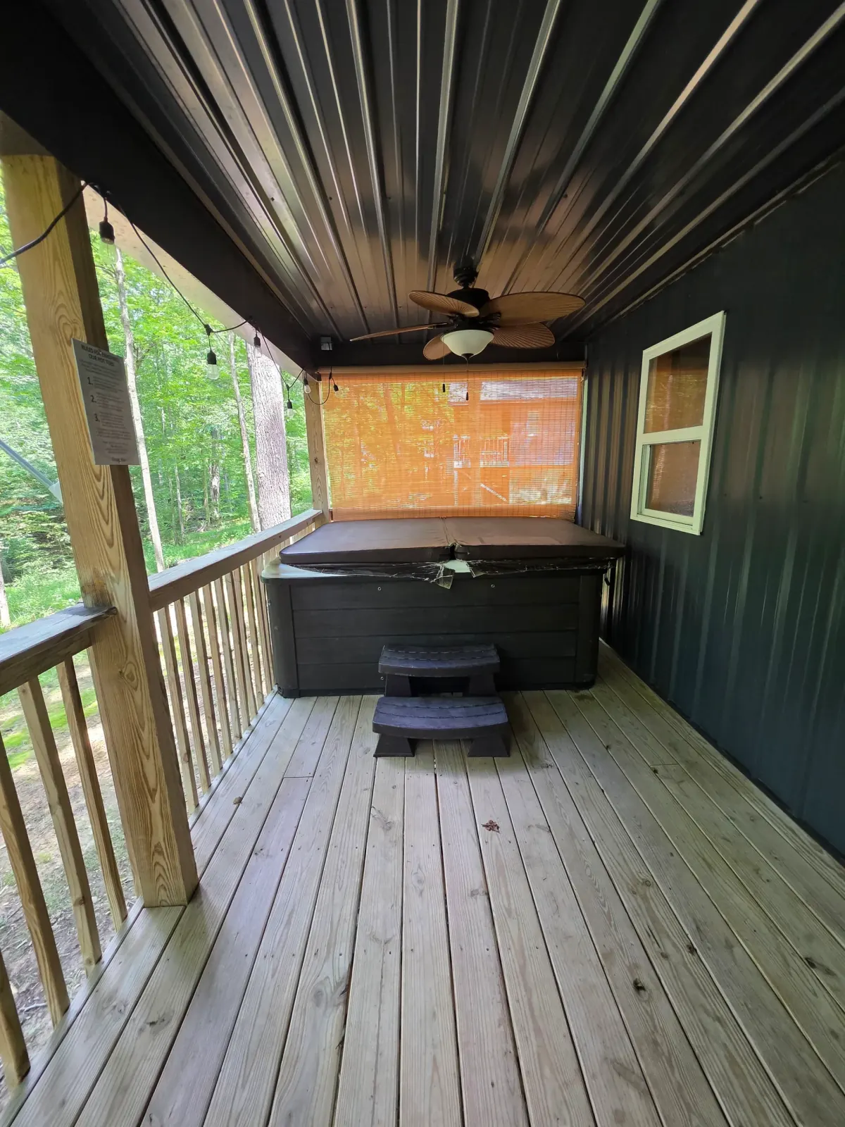Covered deck entry with ceiling fan and wooden door at Dogwood Run cabin