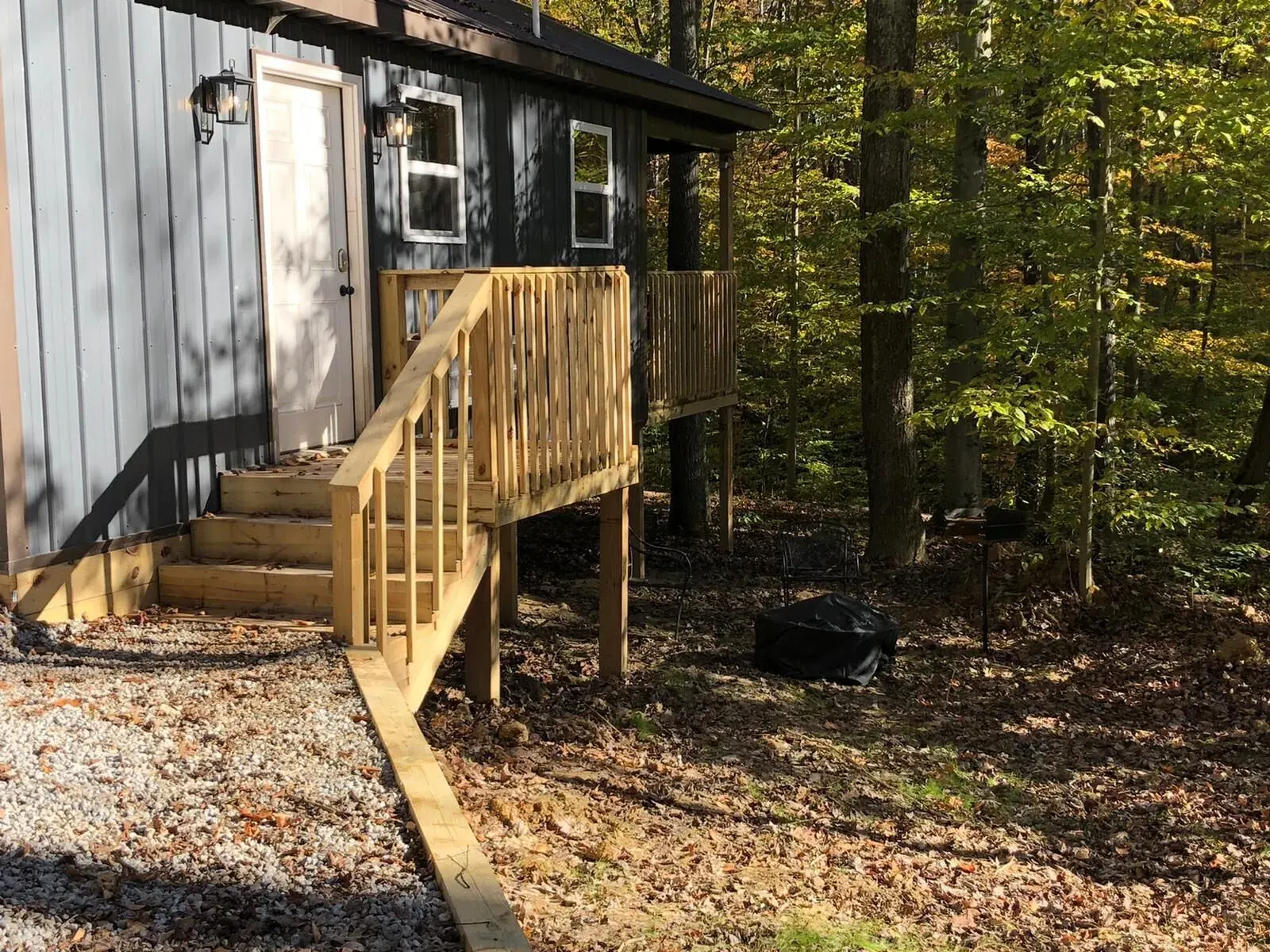 Side view showing wooden steps and deck entrance at Dogwood Run cabin