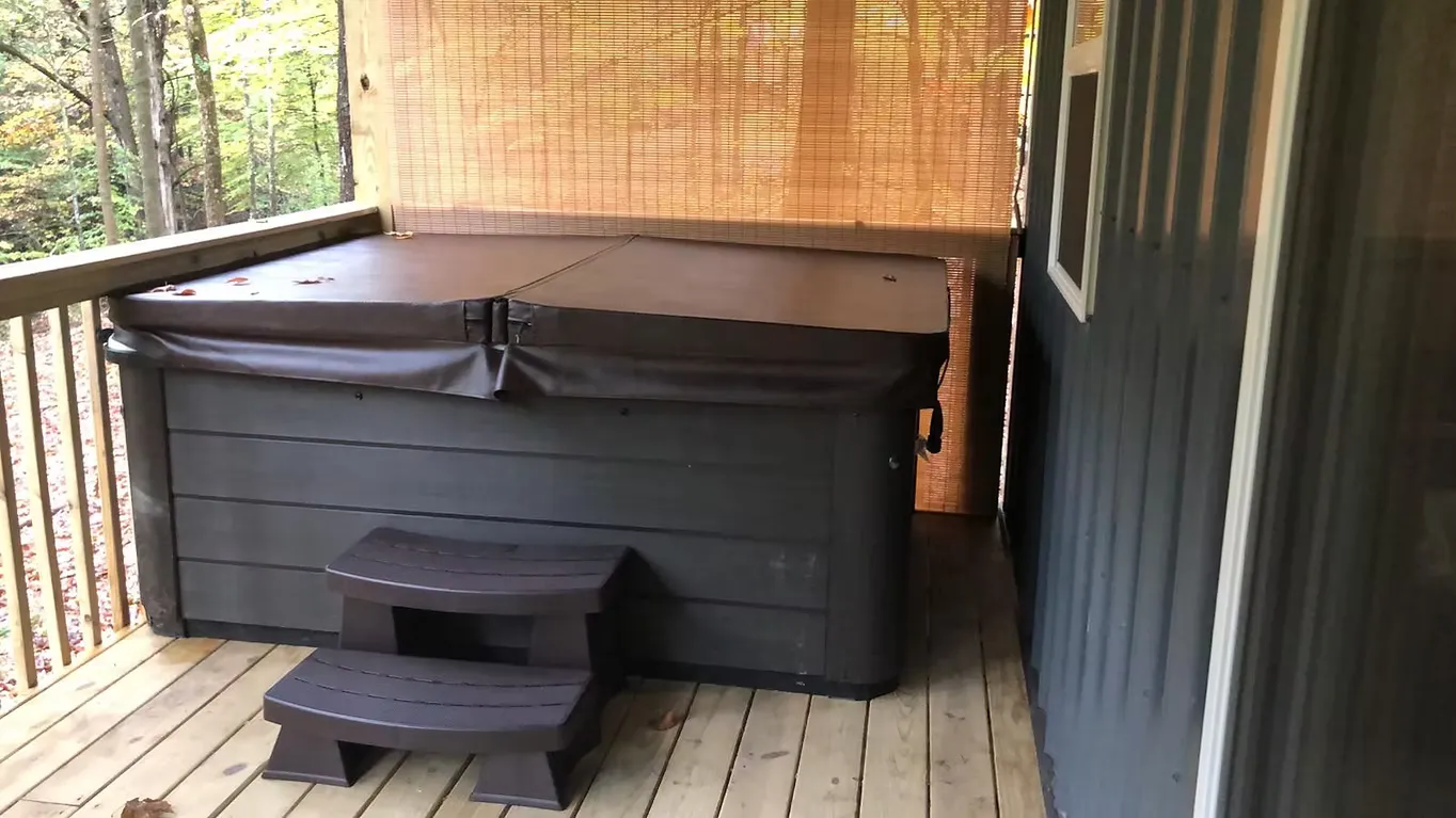 Hot tub with thermal cover on the wooden deck with bamboo shade at Dogwood Run cabin
