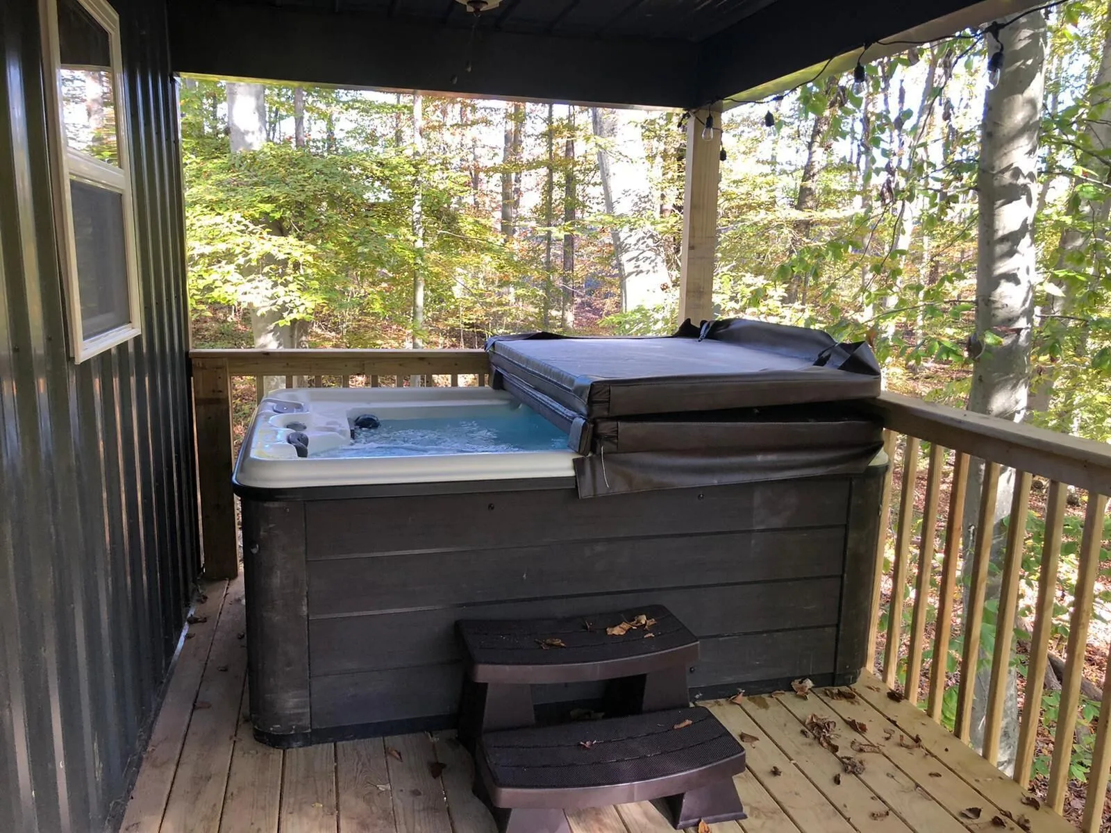 Private hot tub with cover on the shaded deck at Dogwood Run cabin