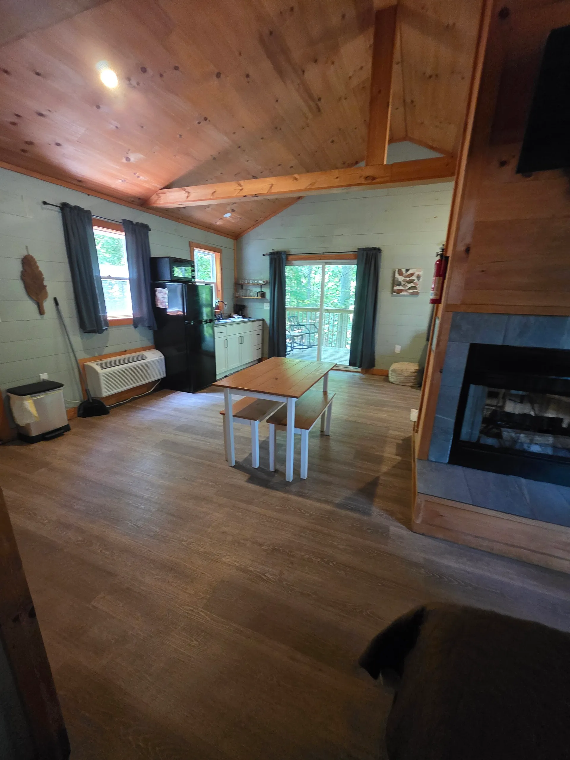 Kitchen and dining overview with white table set, fridge, and wood beam at Dogwood Run cabin