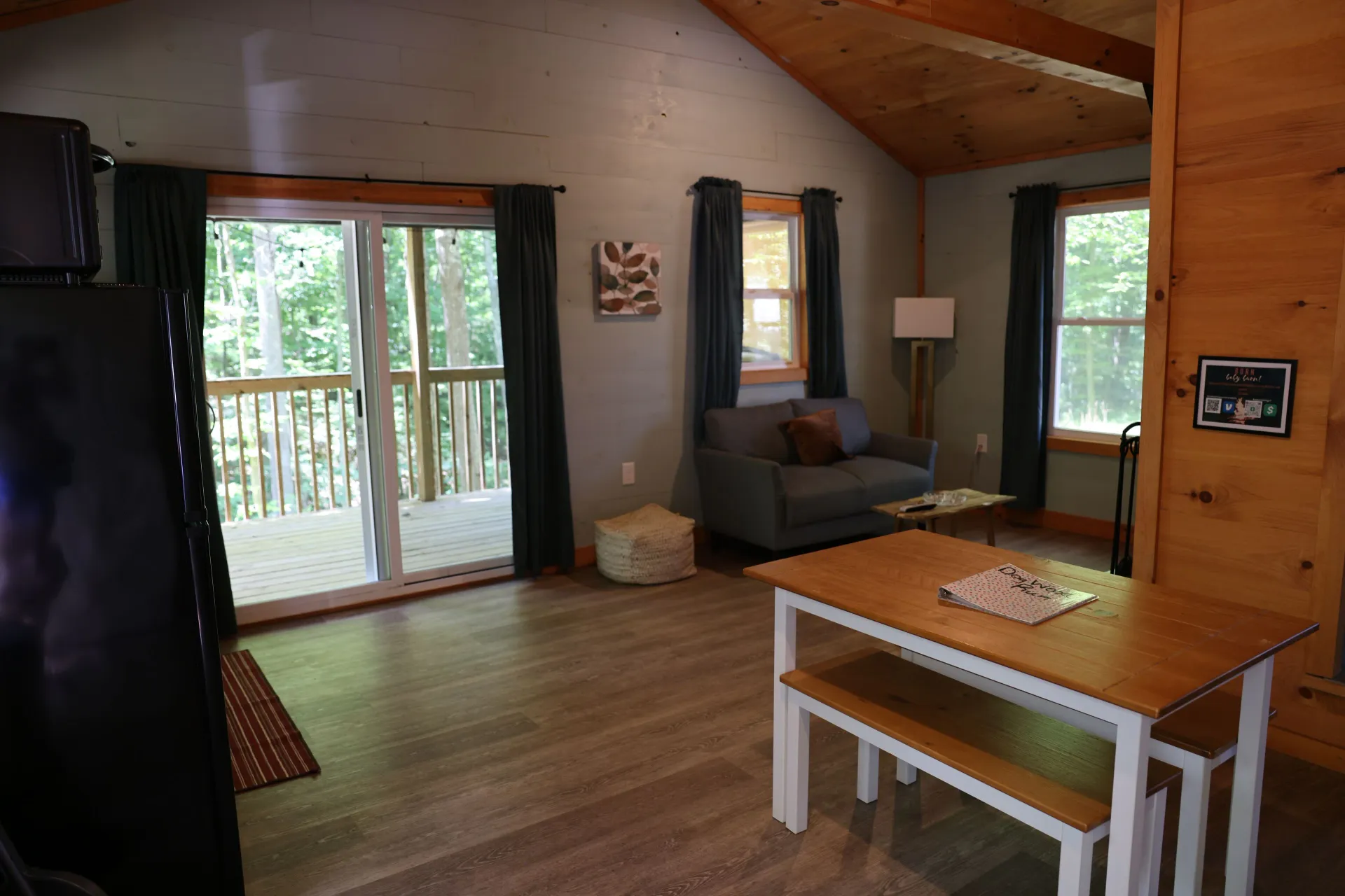 Living room with sofa, dining table with bench seating, and sliding glass door at Dogwood Run cabin