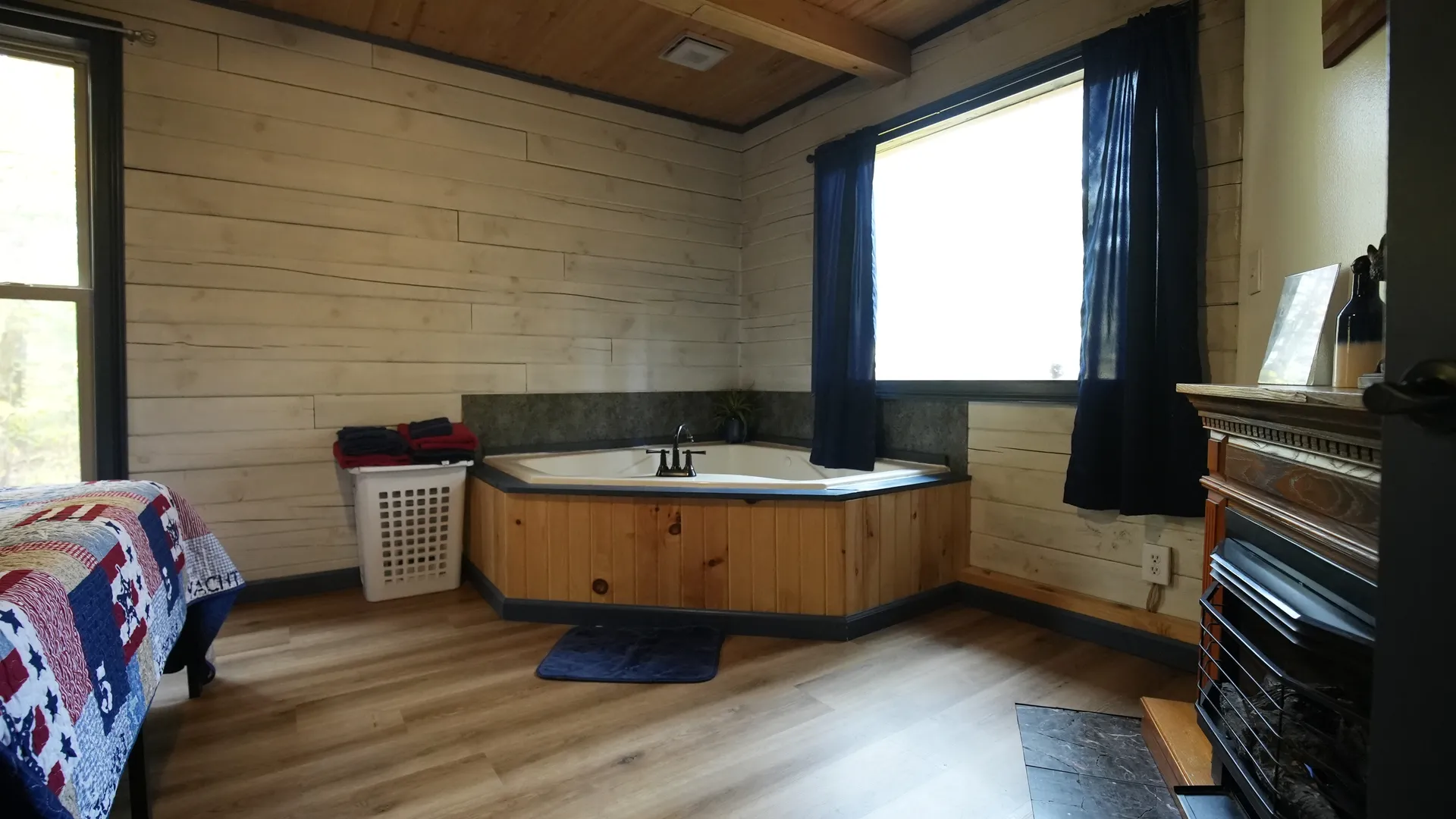 Corner jacuzzi soaking tub with window view and fireplace in Eagles Nest cabin bedroom