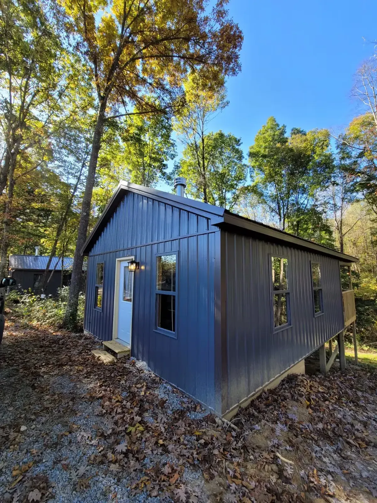 Wide view of Firefly cabin exterior nestled among autumn trees in Hocking Hills