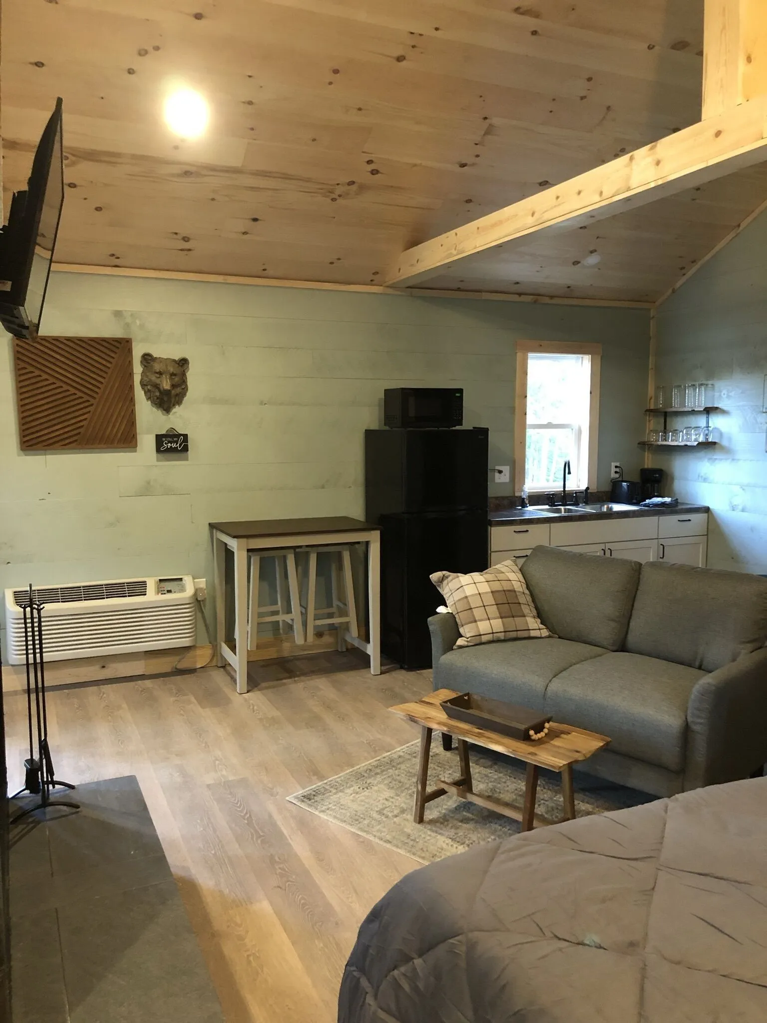 Living and dining area with sofa, dining table, and sliding glass door at Firefly cabin