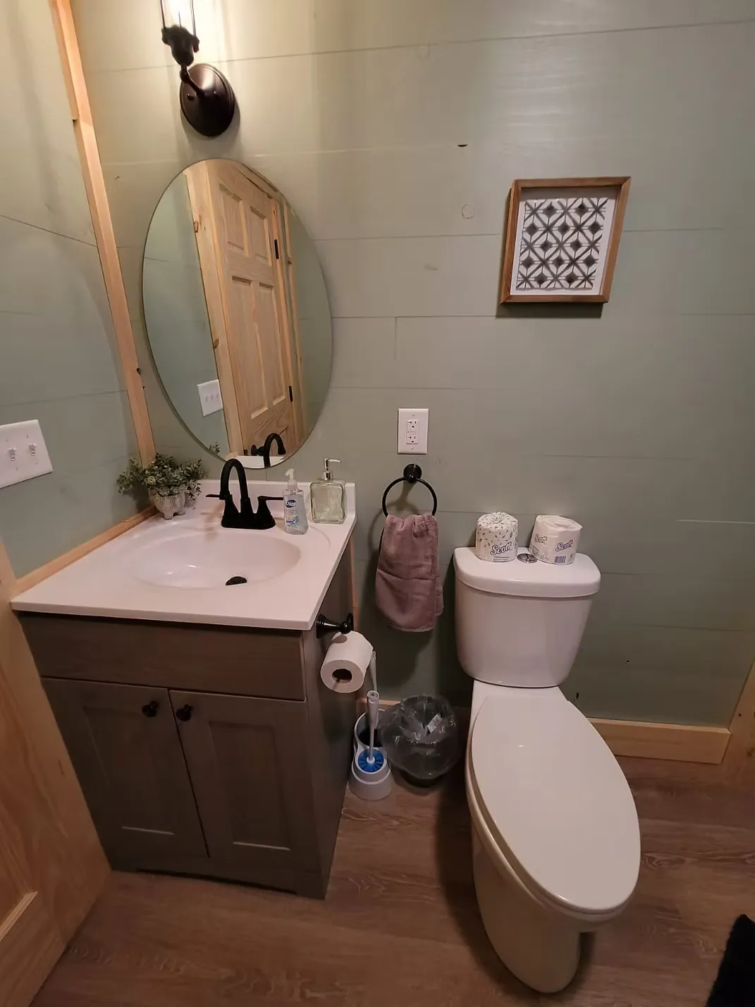 Full kitchenette with white cabinets, black fridge, microwave, and sink at Firefly cabin