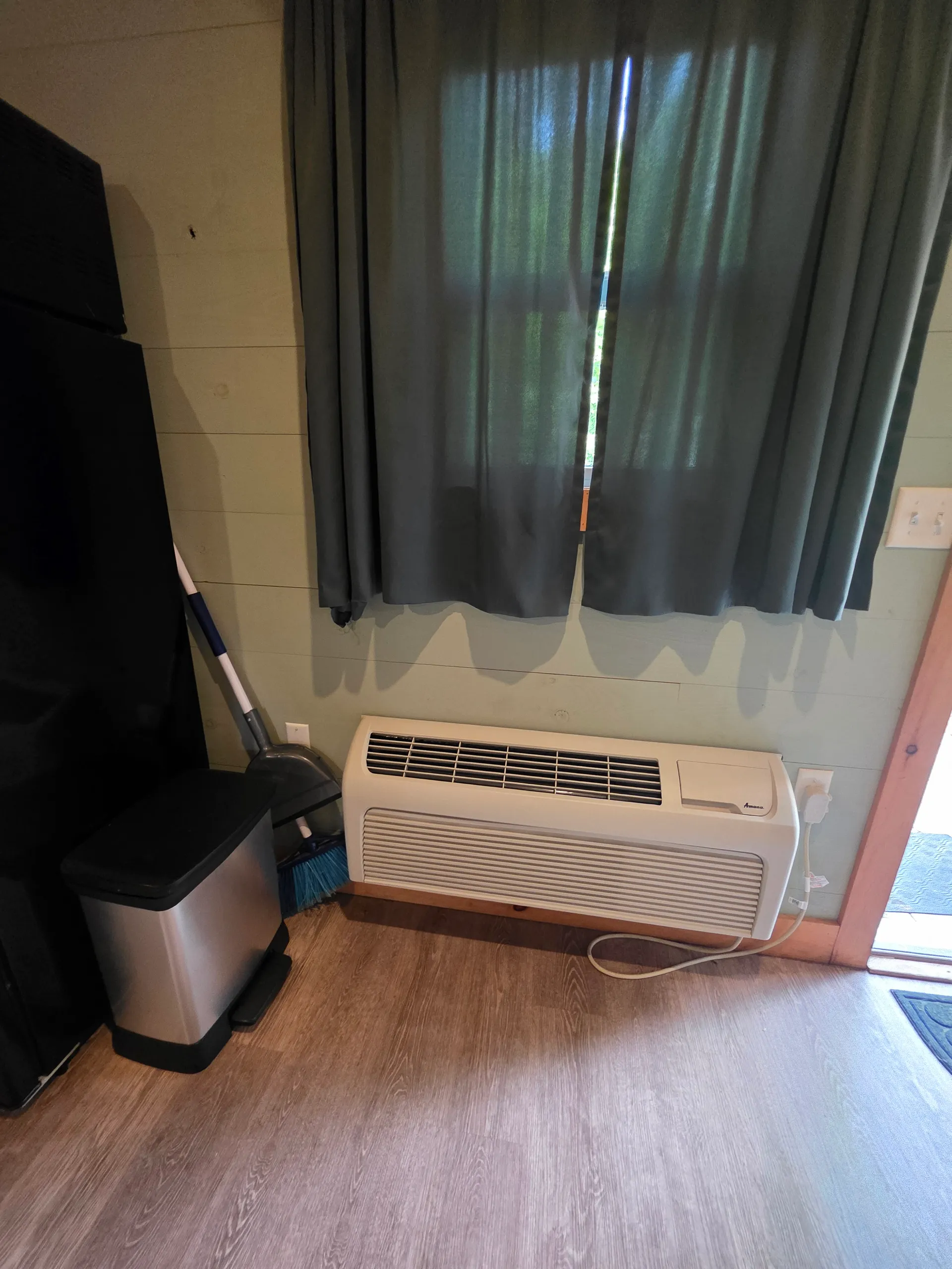 TV area showing AC unit, curtains, and entertainment setup at Forest Aisle cabin