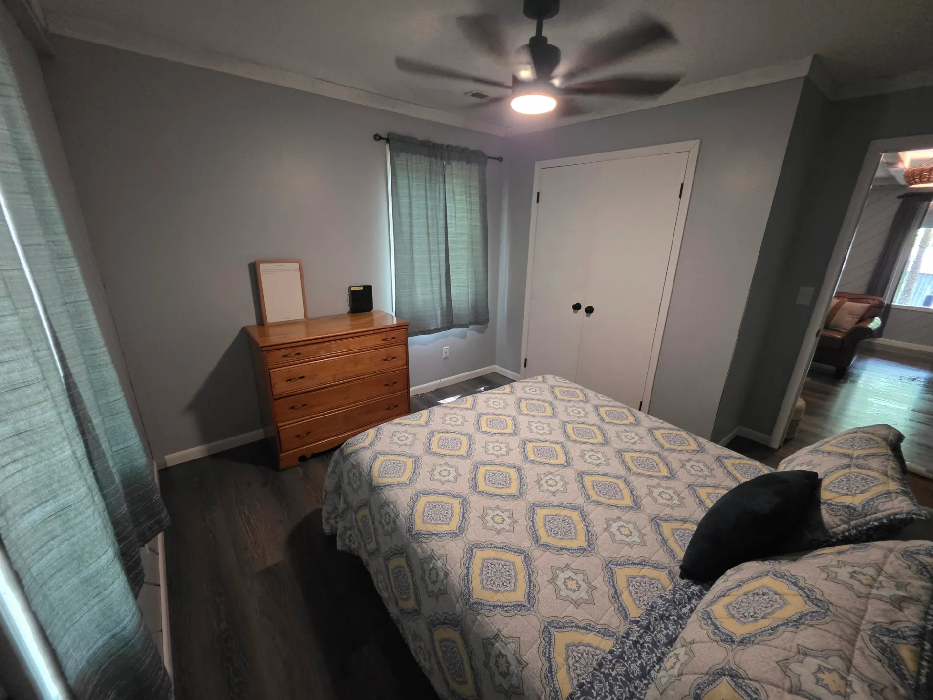 Second bedroom with queen bed, dresser, and ceiling fan at Getaway House cabin
