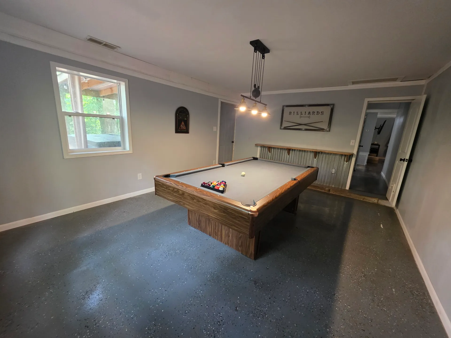 Game room with full-size pool table and billiards sign at Getaway House cabin