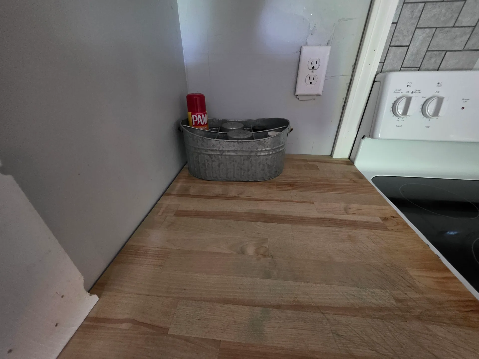 Kitchen counter with cooking supplies and utensil basket at Getaway House cabin