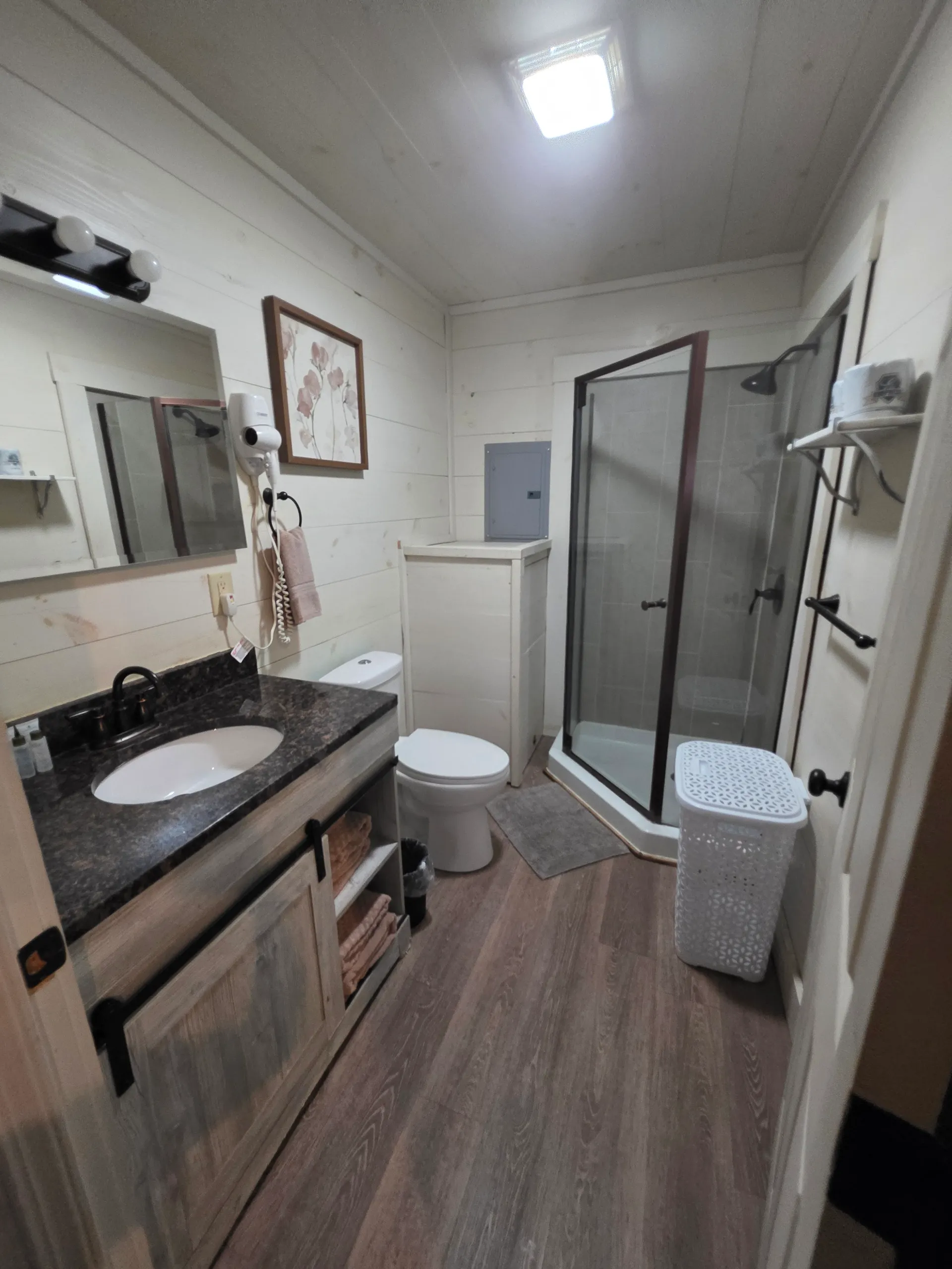 Full bathroom with glass shower, granite vanity, and toilet at Hummingbird cabin