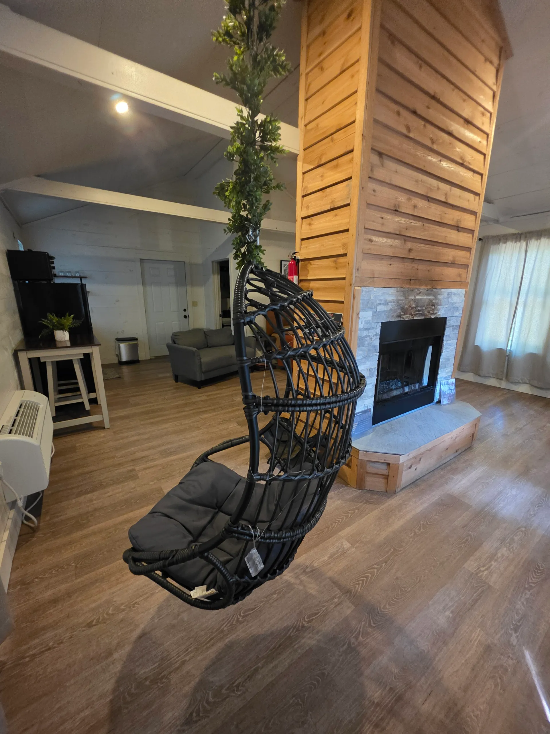 Hanging egg chair and double-sided cedar fireplace viewed from above at Hummingbird cabin
