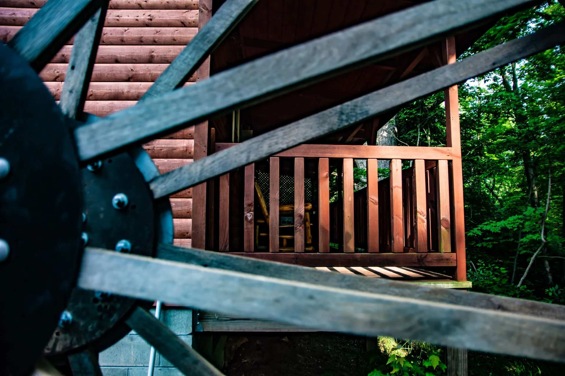 Wooden deck railing and water wheel detail at Millers Den cabin in Hocking Hills