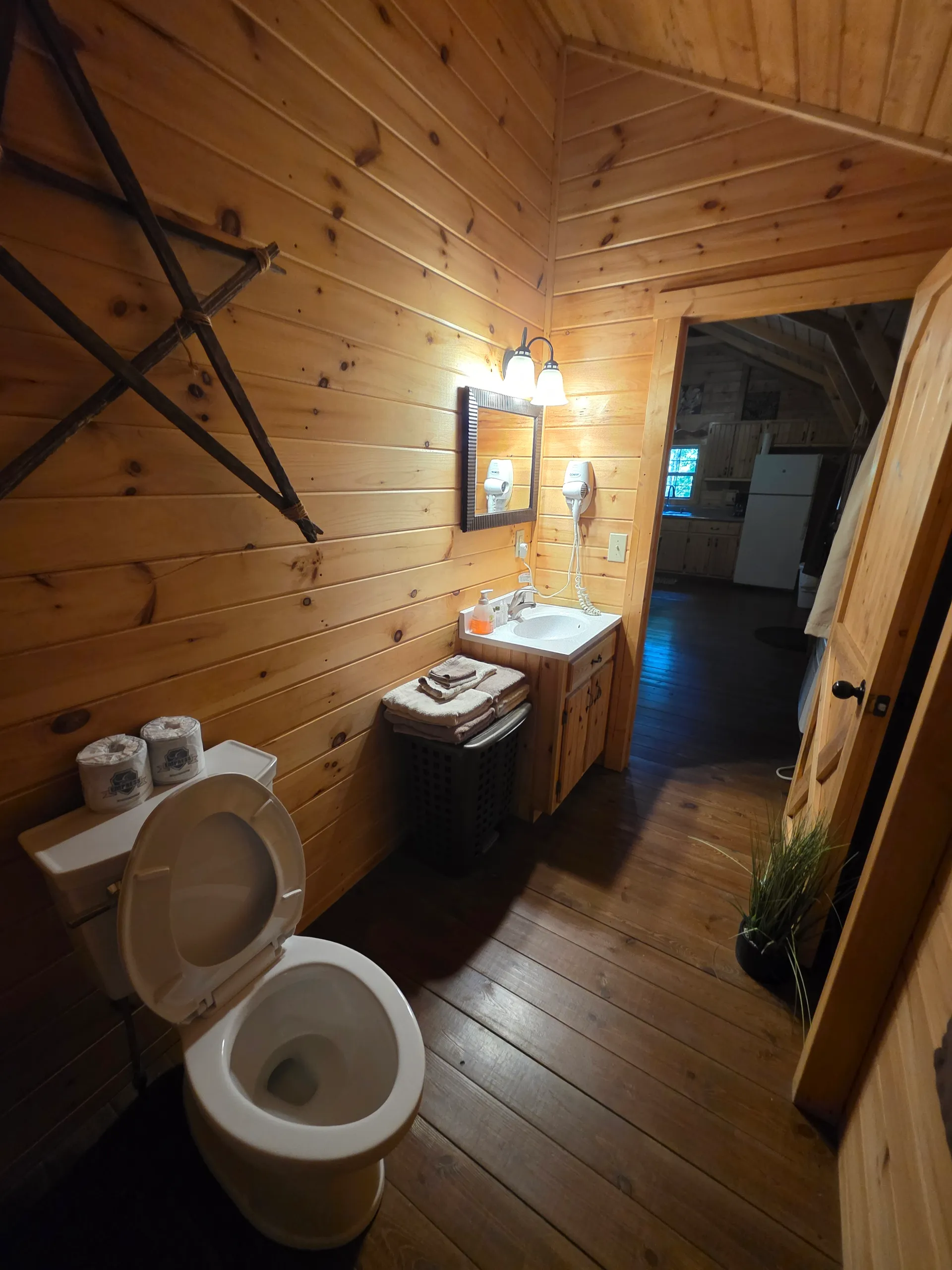 Full bathroom with vanity, toilet, and pine wood throughout at Millers Den cabin