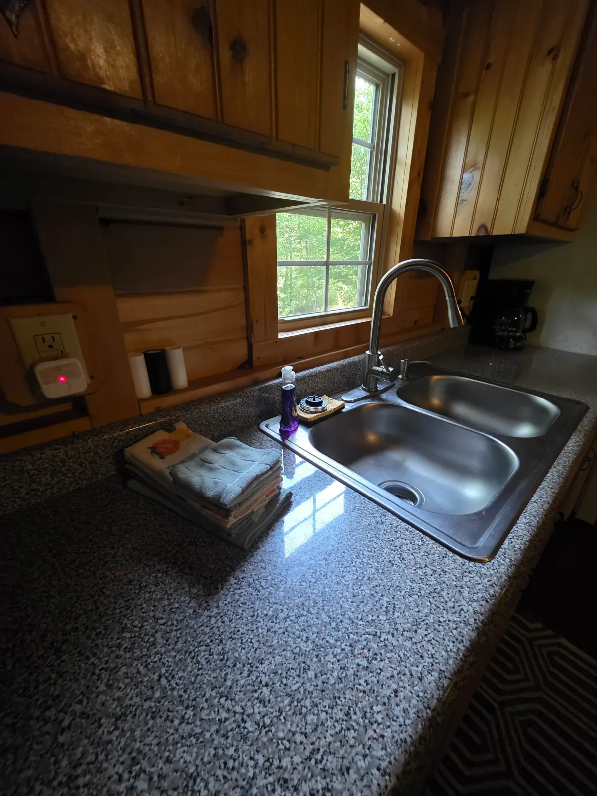 Kitchen sink and granite countertop with natural light at Millers Den cabin
