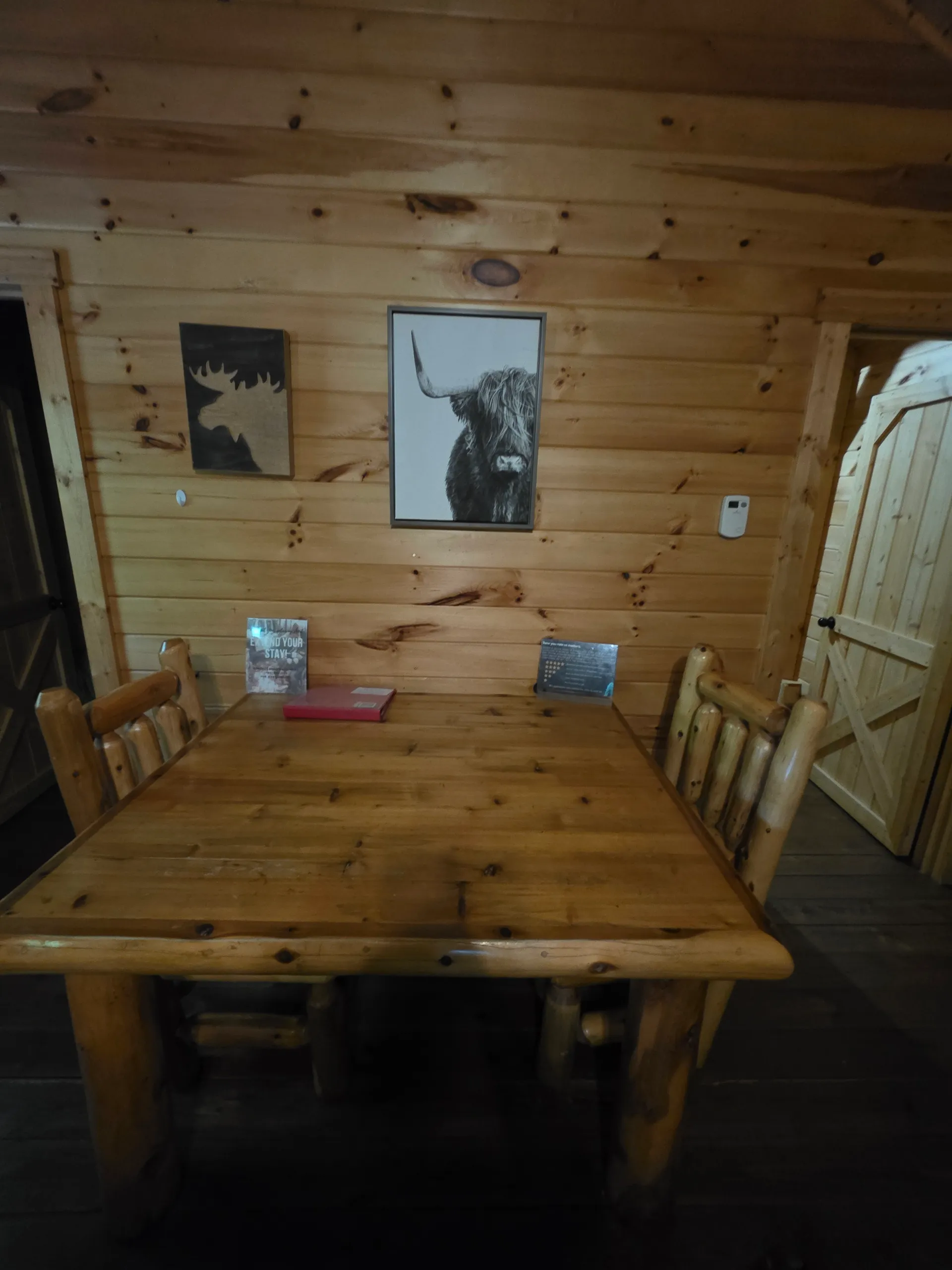 Pine staircase to loft with moose and wildlife wall art at Millers Den cabin