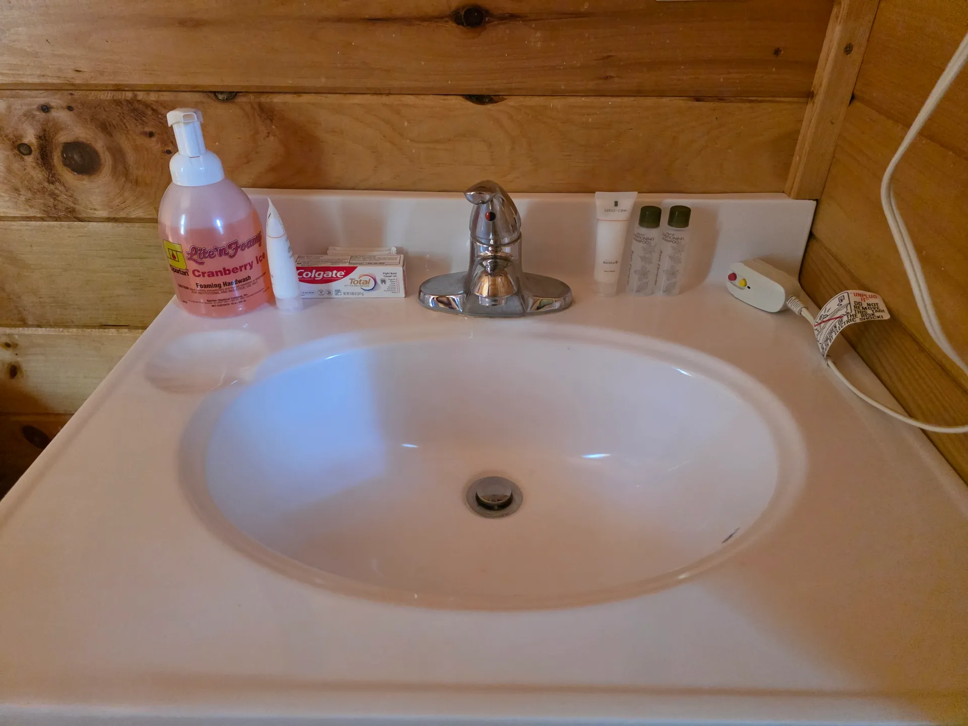 Clean bathroom vanity with white porcelain sink and toiletries in Settlers Roost cabin