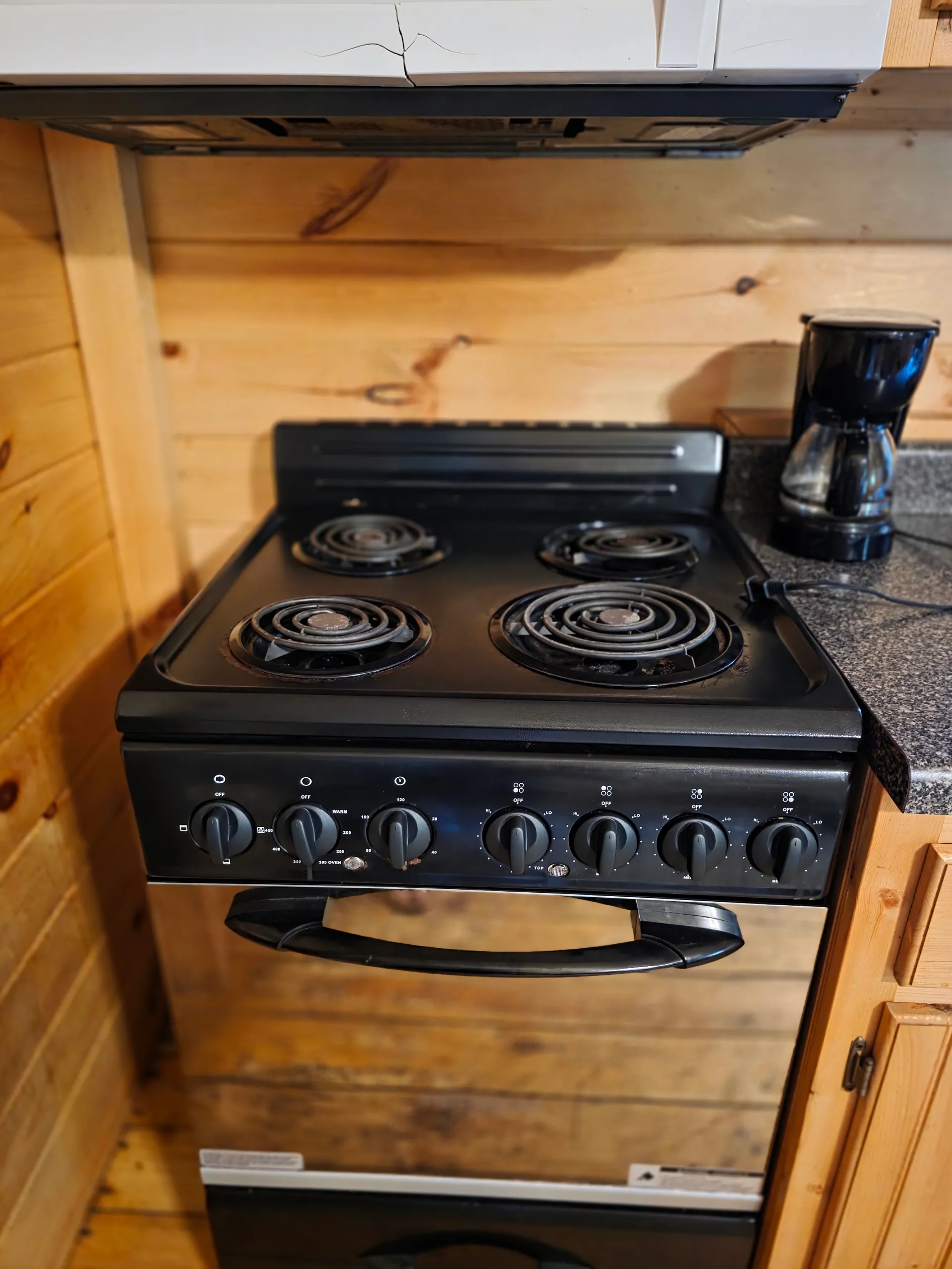 Close-up of four-burner electric stove in the rustic kitchen at Settlers Roost cabin